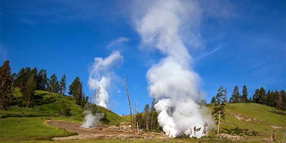 Landscape view of three active geysers with trees, green hills, blue sky, and the moon (Yellowstone National Park, Wyoming) — original digital image © Martha Marks, marthamarksphotography.com, all rights reserved
